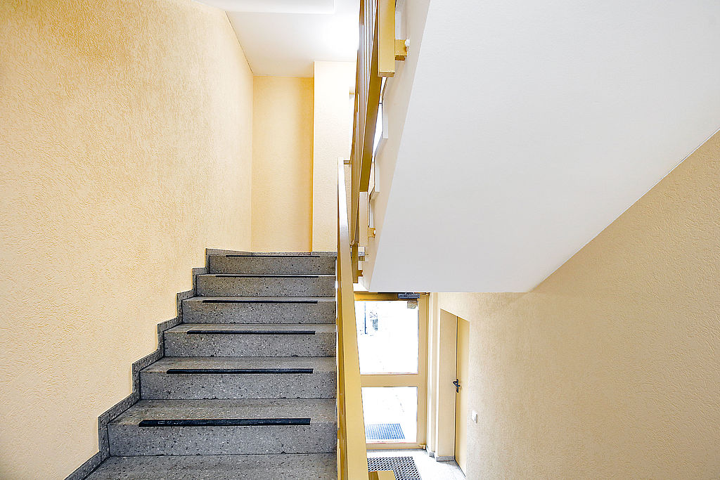Renoviertes Treppenhaus mit gelbem Wandanstrich