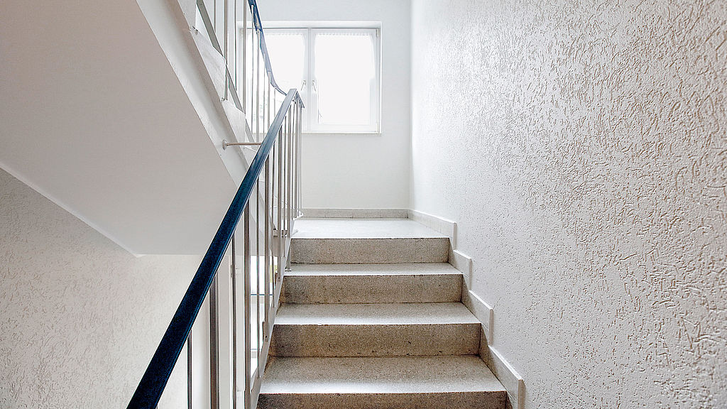 Renoviertes Treppenhaus mit weißem Wandanstrich