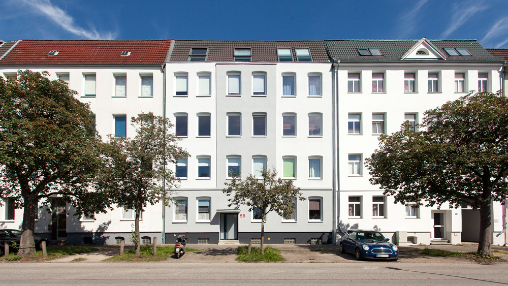 Grau-weißer Fassadenanstrich an einem Mehrfamilienhaus